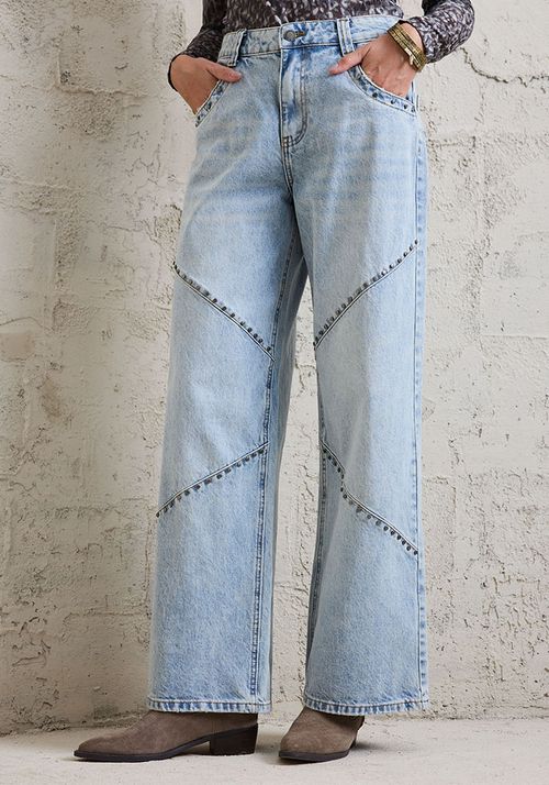 Jeans desgastado con aplicacion de tachas metalicas